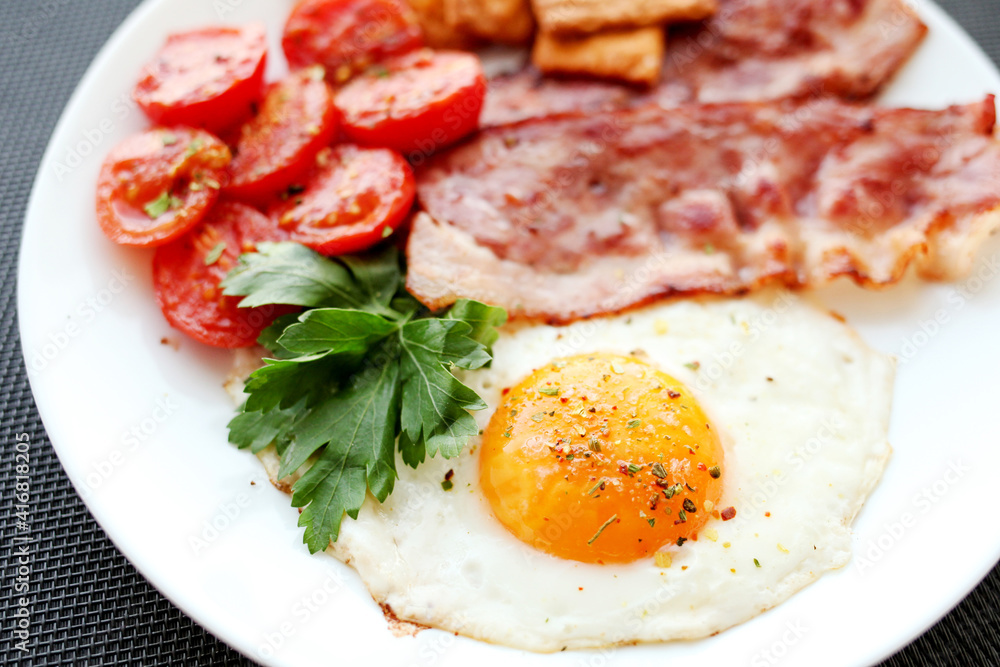 English breakfast - fried eggs, herbs, tomatoes, bacon and crackers