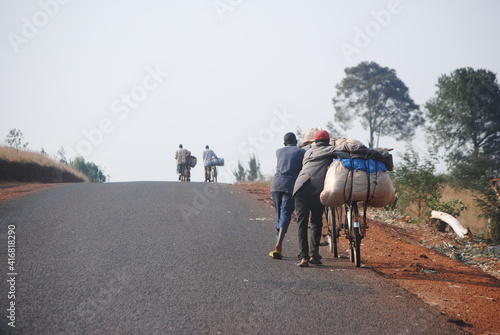 Transport de marchandise à vélo dans la campagne sur la route au Burundi en Afrique