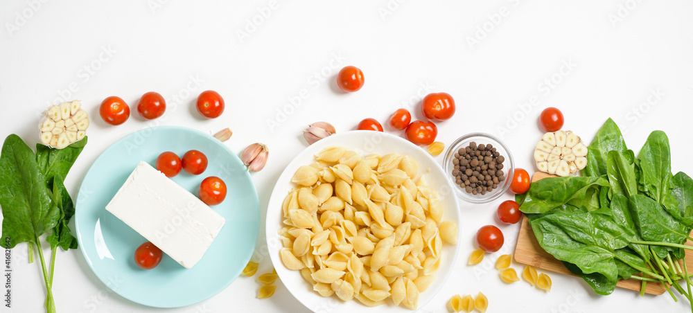ingredients for oven-baked feta cheese with tomatoes and pasta, pepper garlic on a light background top view