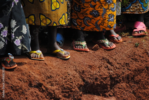 Pieds et tongs, nu-pieds sur un sol en terre rouge au Burundi en Afrique. Habits traditionnels