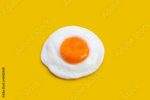 Fried egg on yellow background.