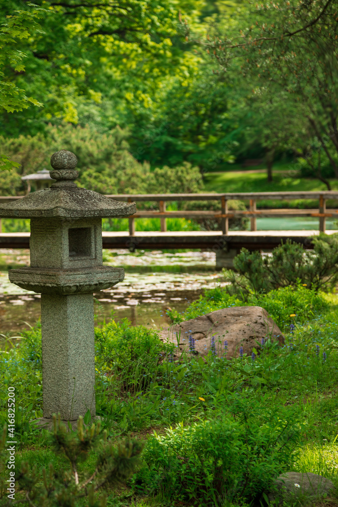 Japanese style park  spring. Stone lanternsin the garden, a traditional decorative element of the Japanese garden.