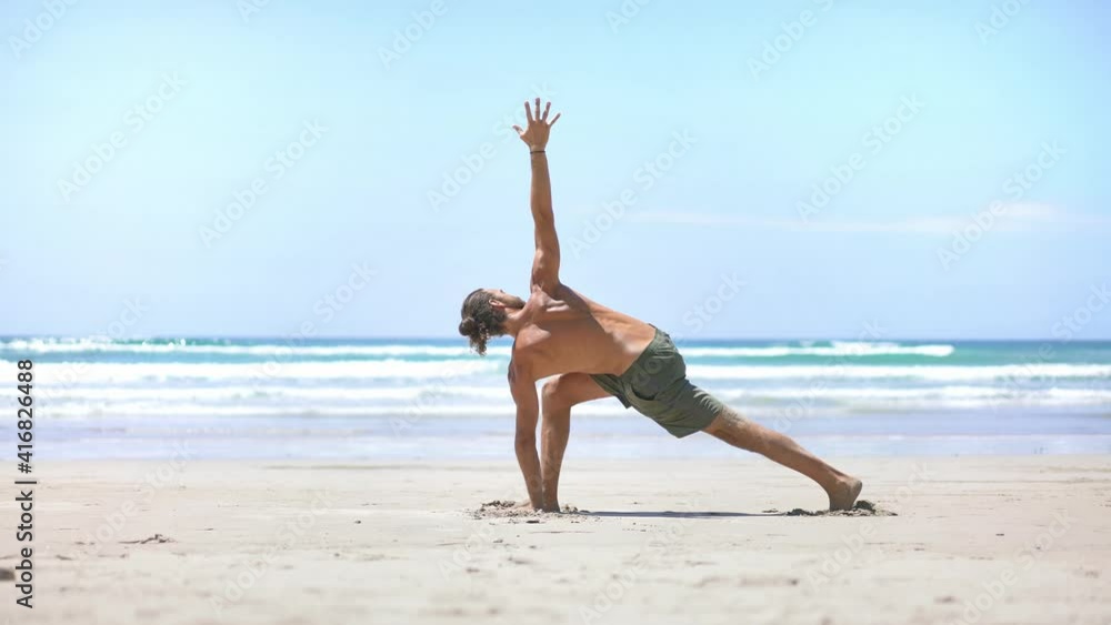 Beautiful young millennial male practice yoga pose on the beach. Confident focused guy. Concept of wellbeing, healthy, mindfulness wellness lifestyle. Beautiful young millennial male practice yoga pose on the beach. Confident focused guy. Concept of wellbeing, healthy, mindfulness wellness lifestyle.