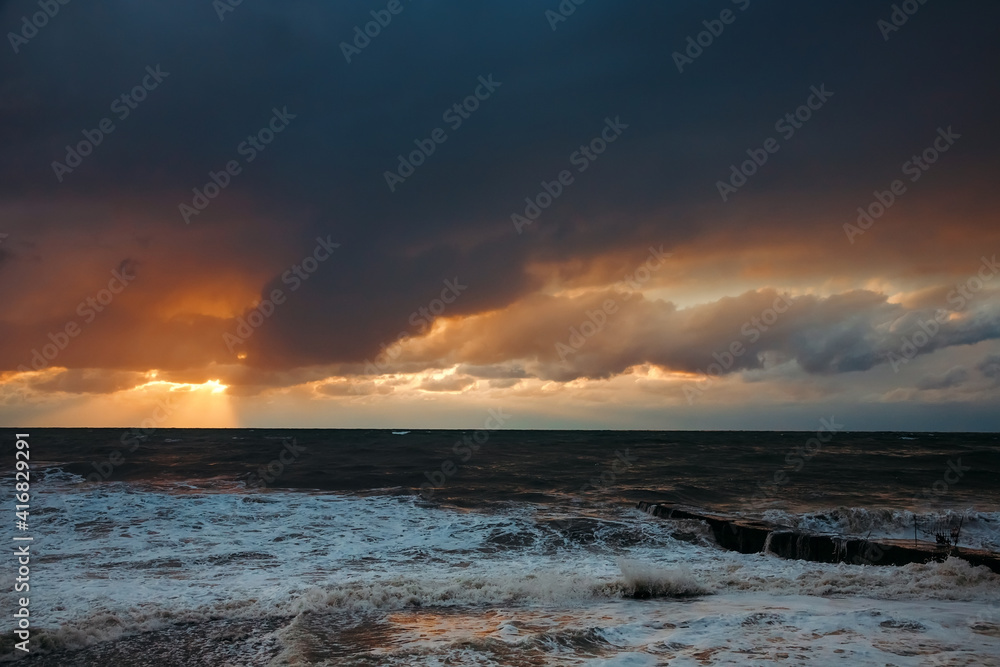 Storm waves near the shore on the beach. In the foreground, breakwaters. Storm waves near the shore on the beach. In the foreground, breakwaters.