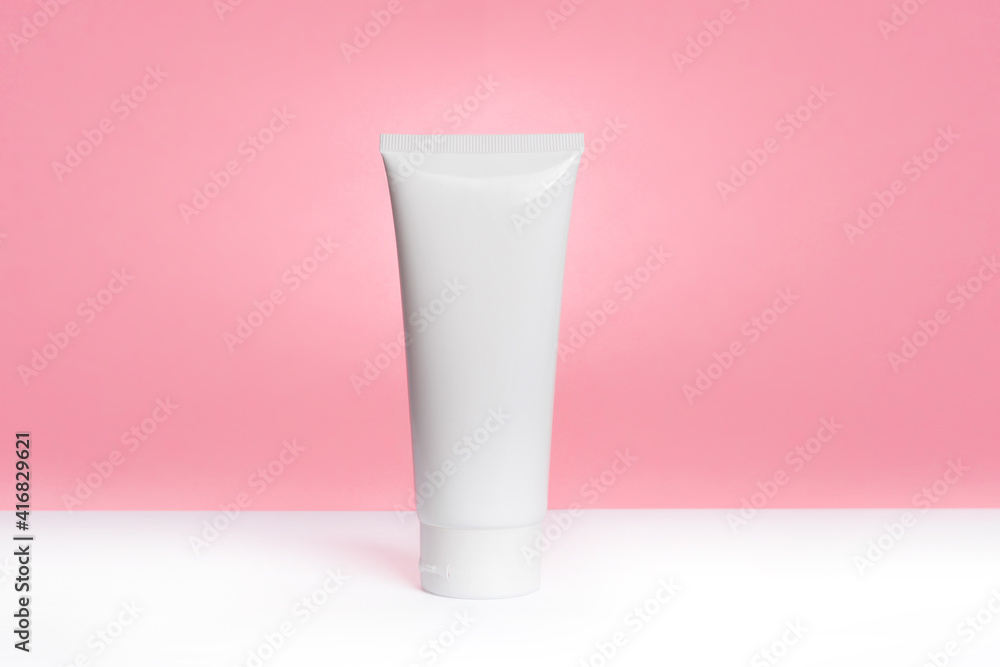 White plastic tube with cream for face, hands and body, light pink. Sun protection lotion, sunscreen. Summer skin care concept with spf flat lay. mockup White plastic tube with cream for face, hands and body, light pink. Sun protection lotion, sunscreen. Summer skin care concept with spf flat lay. mockup