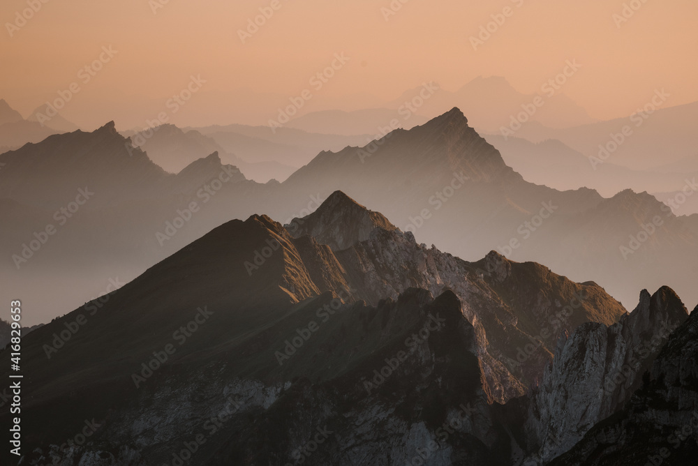 Foggy sunset with beautiful silhouette of mountain range in Switzerland