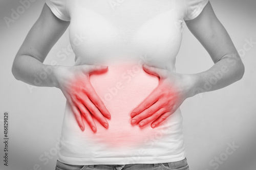 Person woman feeling stomach ache from bloating and indigestion photo