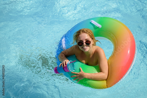 Girl summer vacation. Enjoying suntan. Woman in swimsuit on inflatable circle in the swimming pool.