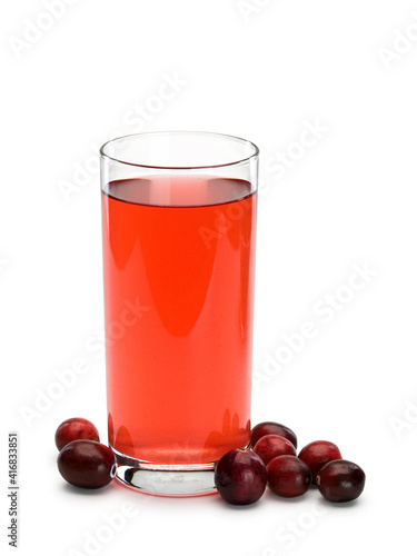 Glass filled with cranberry berry juice and scattering of berries of cranberry