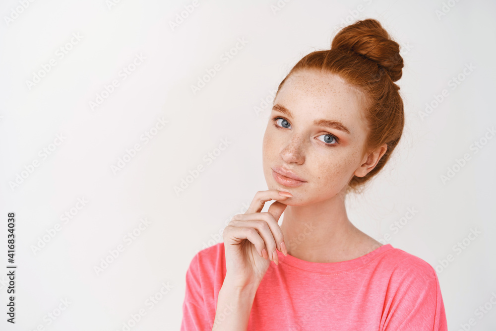 Beauty and skincare. Beautiful young woman taking care of her face with skin care products, looking healthy and pretty without makeup, standing over white background Beauty and skincare. Beautiful young woman taking care of her face with skin care products, looking healthy and pretty without makeup, standing over white background