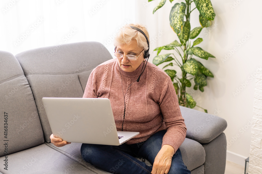 Elder woman using a laptop computer at home Elder woman using a laptop computer at home