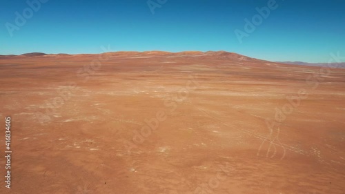 Exploring Atacama Desert vast dry extensions in the driest area of this amazing desert with an all terrain vehicle. An awe road trip adventure crossing the infinite sand extensions from an aerial view