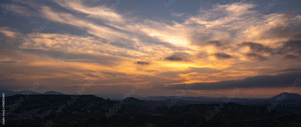Panoramic mountain landscape with cloudy sky at sunset