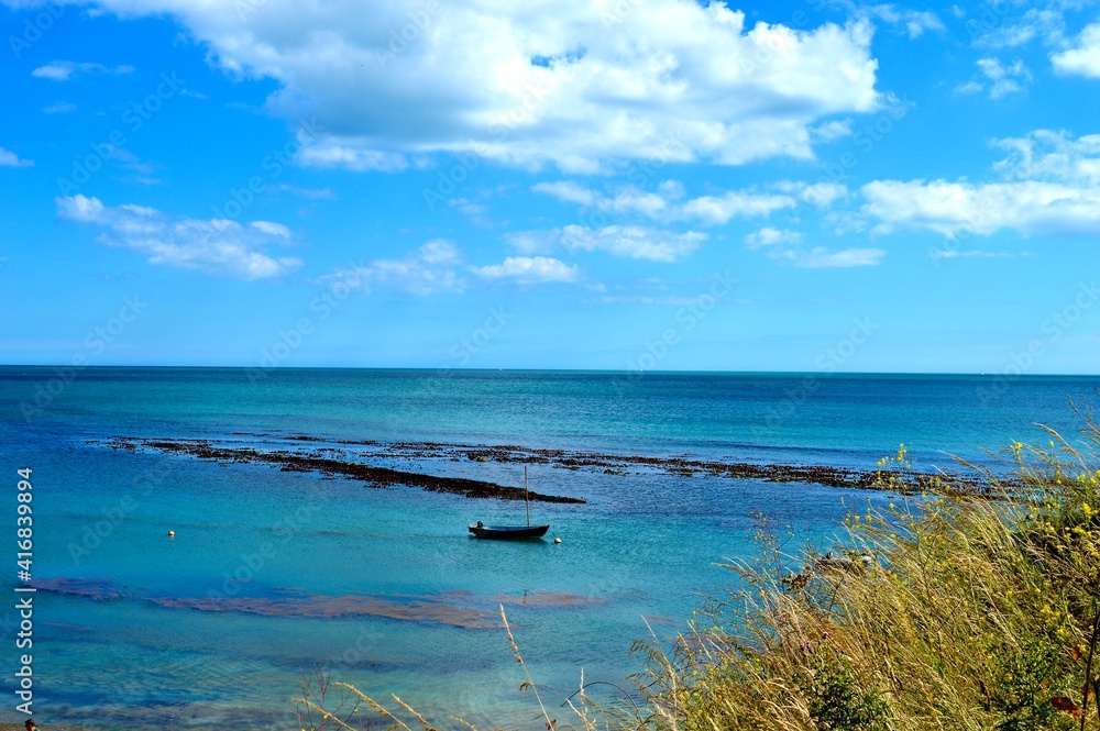 Stunning Shot of Lone Anchored Sailing Boat With Bouys, Seaweed, and Stretching Deep Blue Ocean Behind, Osmington