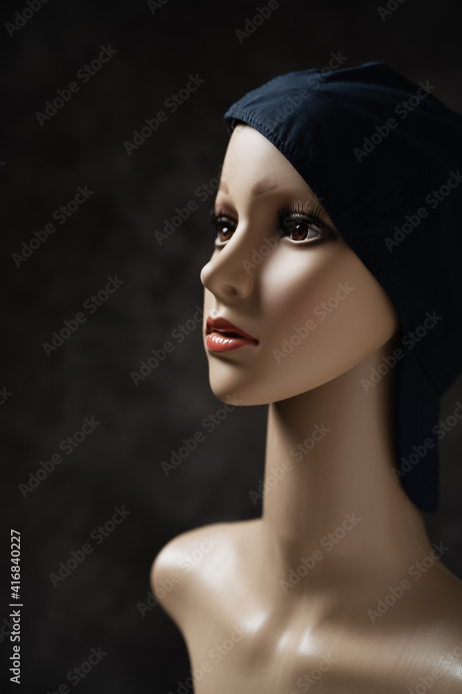 Mannequin wearing a cap in front of the black background Mannequin wearing a cap in front of the black background