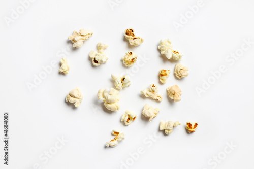 Ready popcorn sprinkled on a white background.