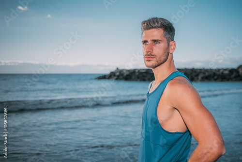 a young man exercises on the beach at sunset on a beach