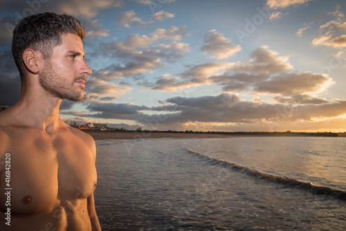 a young man exercises on the beach at sunset on a beach. Warm colors