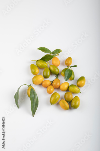 Fresh ripe kumquats with leaves on white background
