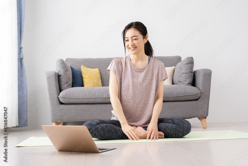 家でヨガをするミドル女性