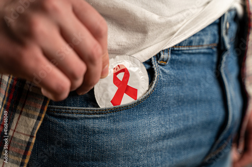 Cuadro en lienzo Close up of young man taking condom out of pocket in jeans