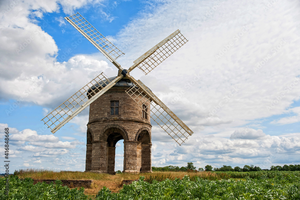Chesterton Windmill near Leamington Spa, Warwickshire a 17th-century cylindrical stone tower mill with an arched base under a blue sky , white clouds , summers day. Chesterton Windmill near Leamington Spa, Warwickshire a 17th-century cylindrical stone tower mill with an arched base under a blue sky , white clouds , summers day.