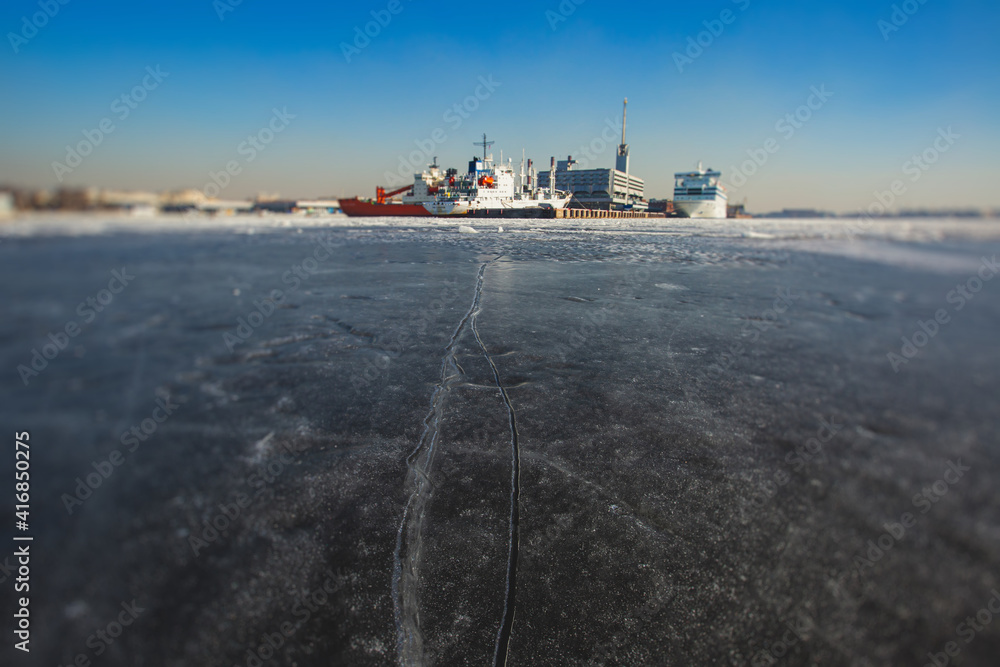 Massive different ship vessels trapped in ice tries to break and leave the bay between the glaciers, icebreaker and carrier vessel, winter blue sky view