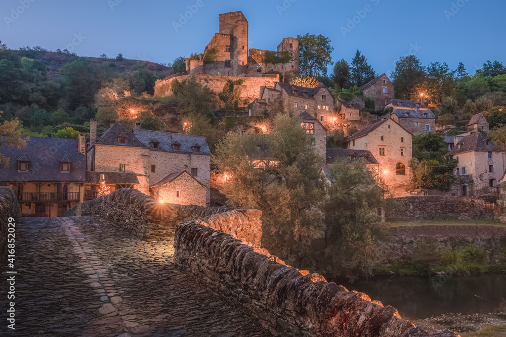 Along the old stone bridge in the quaint and charming medieval French village of Belcastel, Aveyron on a summer night in the Occitanie region of France.
