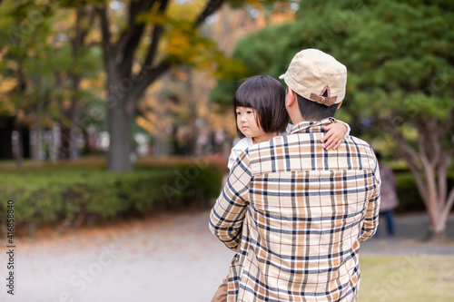 秋の公園で遊ぶ父親と子供 