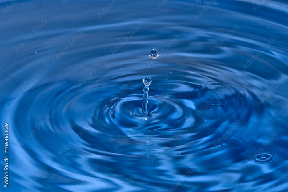 Closeup of water drops on blue water ripple background Closeup of water drops on blue water ripple background