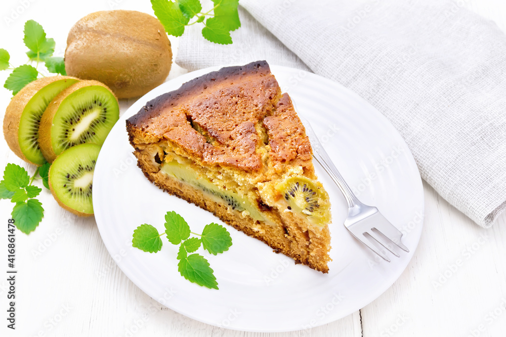 Pie with kiwi in plate on wooden board Pie with kiwi in plate on wooden board