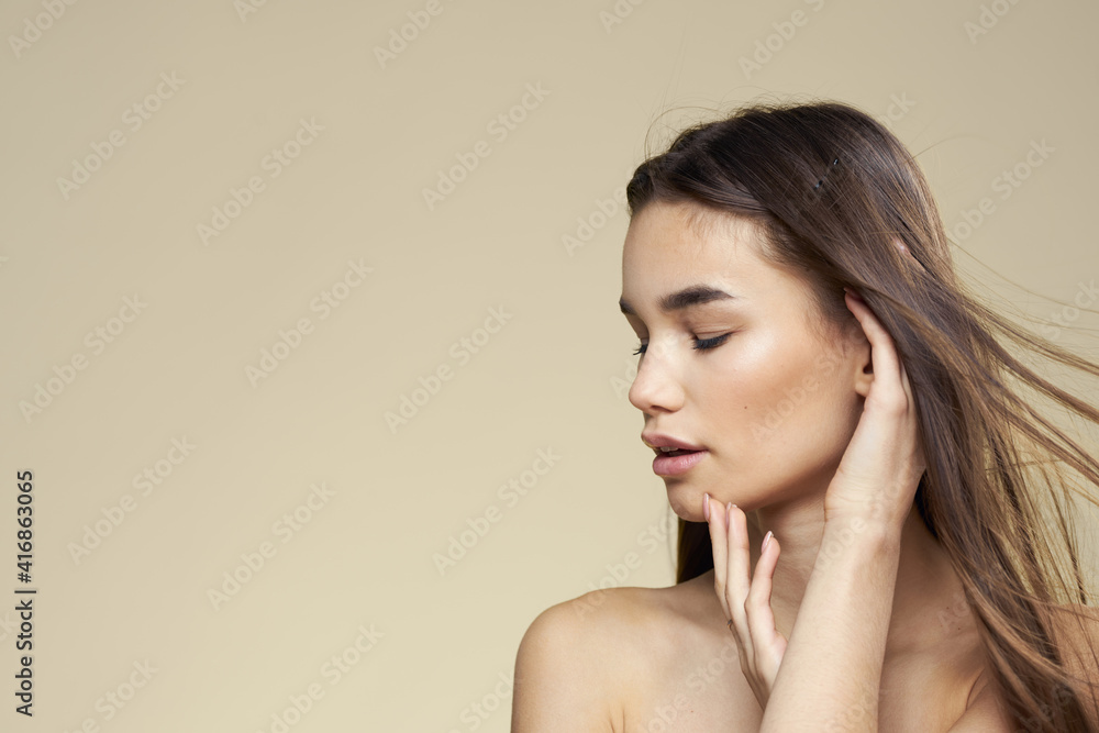 Obraz premium Pretty woman naked shoulders long hair body care beige background