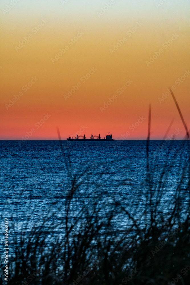 Ship in the ocean past sunset