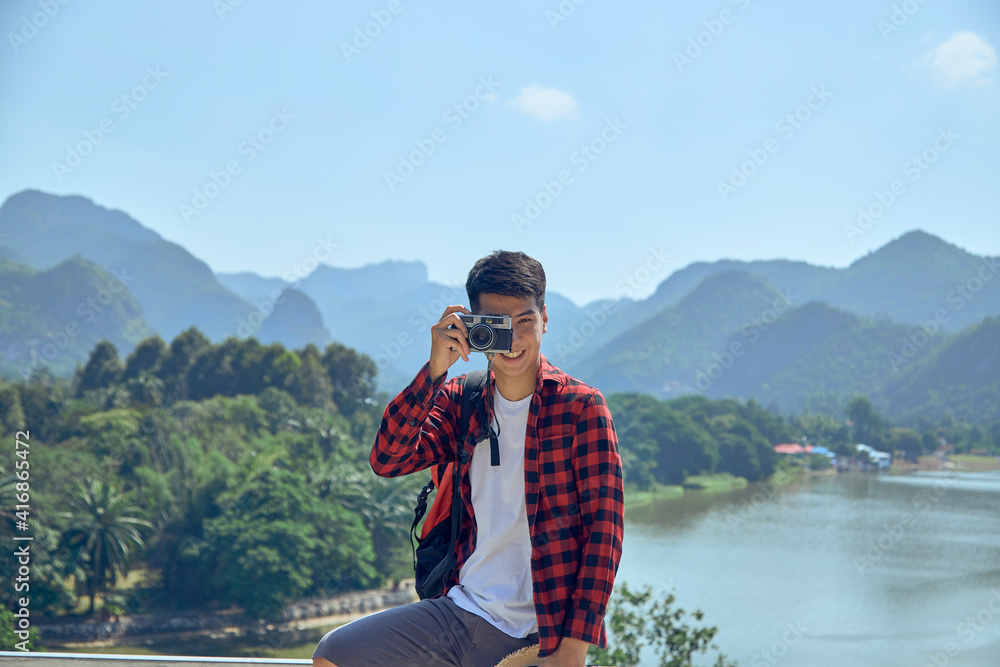 Young man photographing with vintage camera