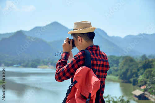 Young man photographing with vintage camera