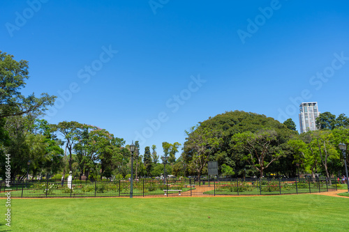 Beautiful public park full of roses of different types and colors with the city in the background. Rosedal de Palermo in Buenos Aires, Argentina. Panoramic view.