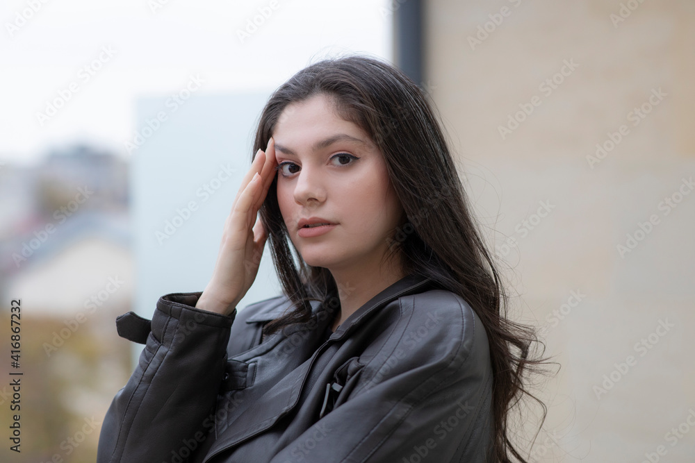 Image of young brunette girl standing on terrace while looking at camera Image of young brunette girl standing on terrace while looking at camera