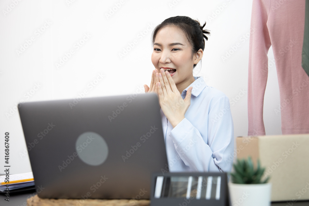 Young Asian woman congratulated and smiled as a large number of customers ordered her clothes online, Business of selling clothes on social media or selling online, Feel excited or surprise or shocked Young Asian woman congratulated and smiled as a large number of customers ordered her clothes online, Business of selling clothes on social media or selling online, Feel excited or surprise or shocked