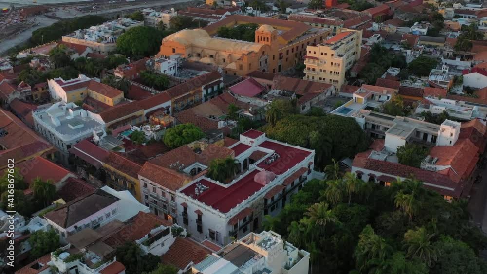 Sunset Aerial travel over Houses in Old Town with Pool and Palm Trees and Sea in Cartagena de Indias, Bolivar, Colombia Sunset Aerial travel over Houses in Old Town with Pool and Palm Trees and Sea in Cartagena de Indias, Bolivar, Colombia