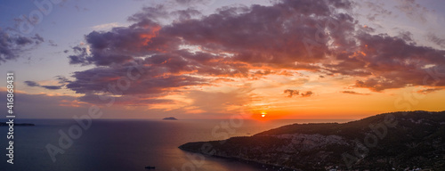 Aerial panoramic drone shot sunset over Adriatic horizon from Komiza town port on Vis Island in Croatia summer