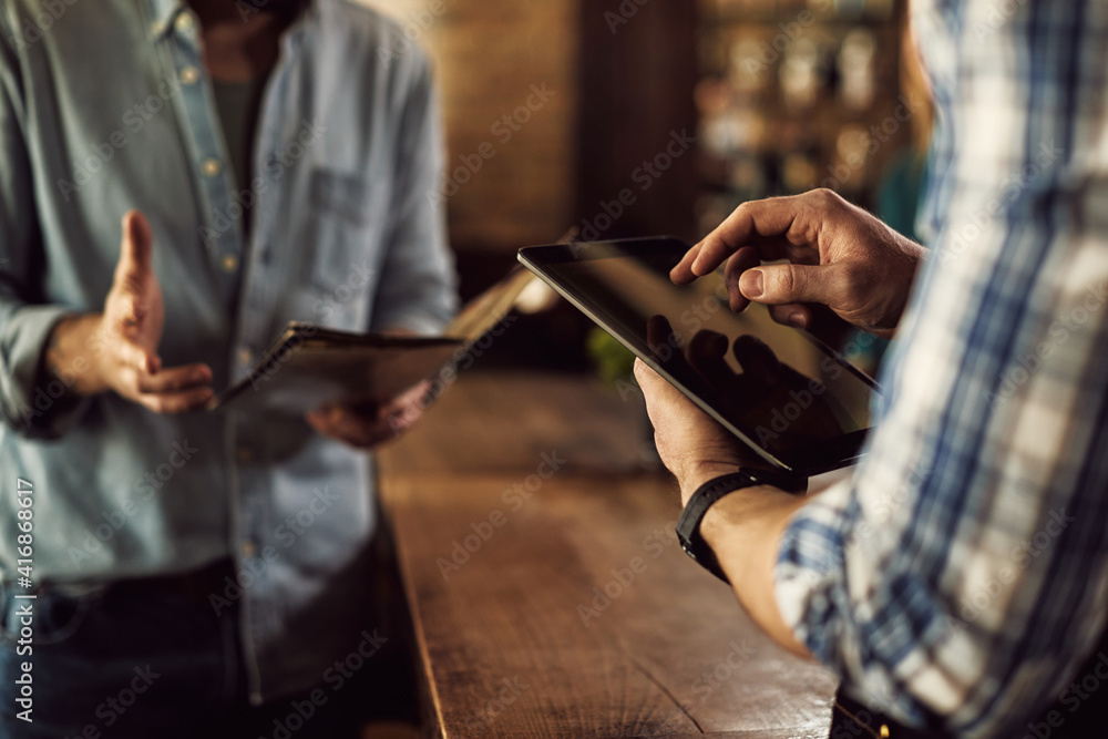Close-up of waiter taking order on digital tablet in a cafe. Close-up of waiter taking order on digital tablet in a cafe.
