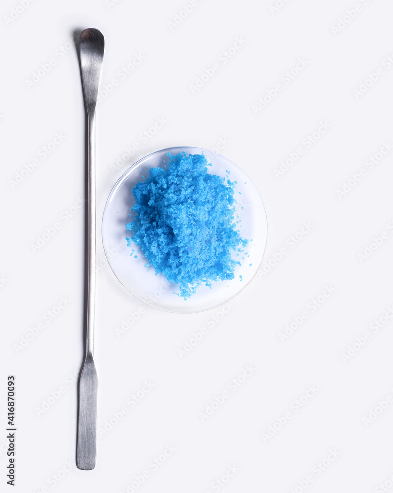 Copper(II) sulfate in Chemical Watch Glass placed next to the stirring rod on laboratory table. Copper(II) sulfate in Chemical Watch Glass placed next to the stirring rod on laboratory table.