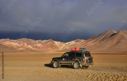 Four-wheel car with the beautiful palette of colors in the Salvador Dali Valley, Salar de Uyuni, Bolivia