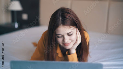 woman with laptop lies in bed sleeping room rest communication