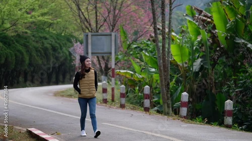 Wallpaper Mural Slow motion of a young asian woman walking on the street with nature in background Torontodigital.ca
