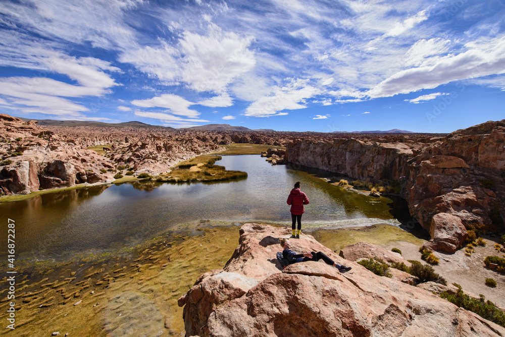 Tourist enjoying the beautiful view of the hidden Laguna Negra Valley in the Salar de Uyuni, Bolivia