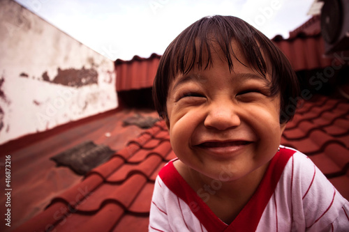 portrait of a child smiling using red strip shirt