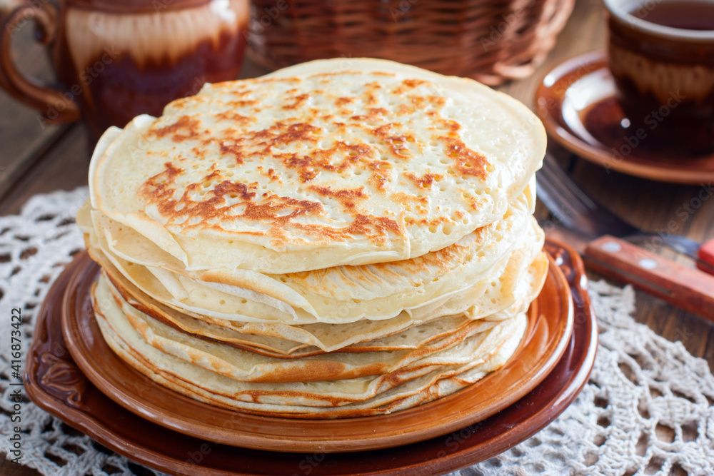 Homemade thick pancakes stacked on a plate, selective focus Homemade thick pancakes stacked on a plate, selective focus