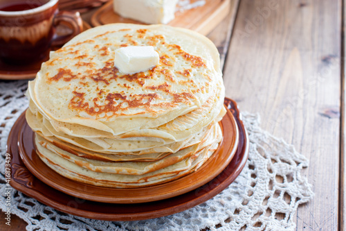 Homemade thick pancakes stacked on a plate, horizontal, copy space