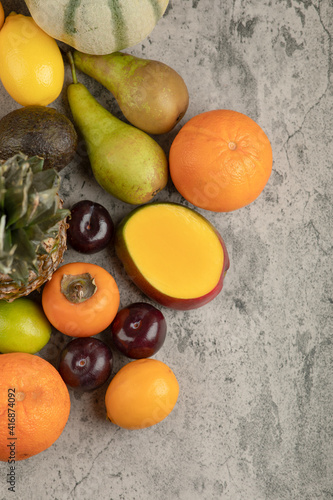 Bunch of various delicious fresh fruits on marble surface
